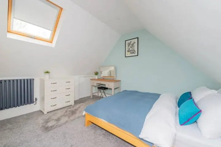 Second bedroom with a skylight and soft blue bedding